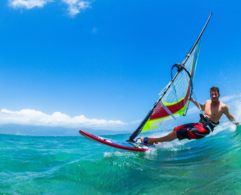 image of windsurfer carving down wave