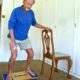 Peter Smith, 75, on his CoolBoard Wobble Board. He is doing balance exercise for elderly on the Easy Start Balance Disc using a chair for support.