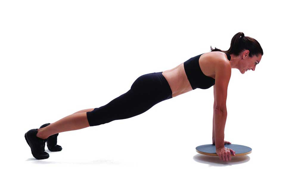 woman exercising on a wobble board woman does plank exercise on wobble board