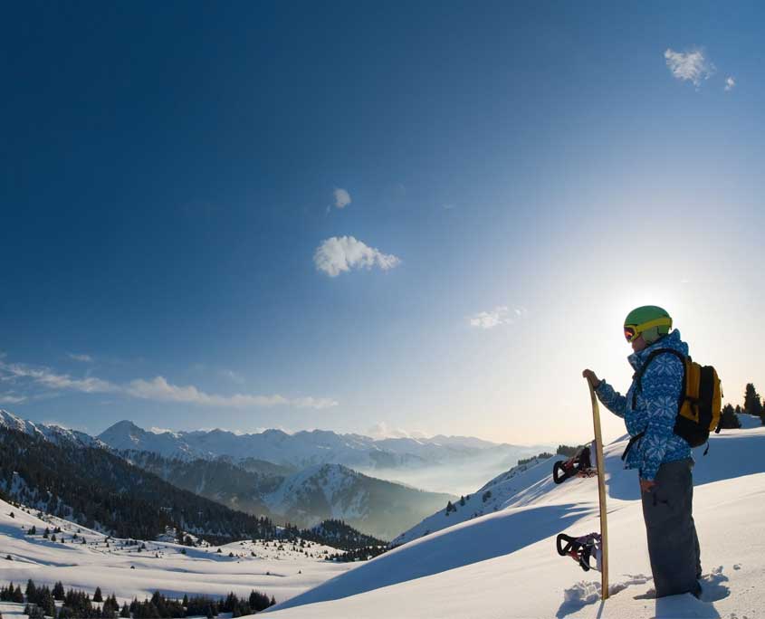 image of snowboarder at top of snow covered valley