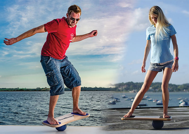 man and a woman on coolboard balance boards on the ball