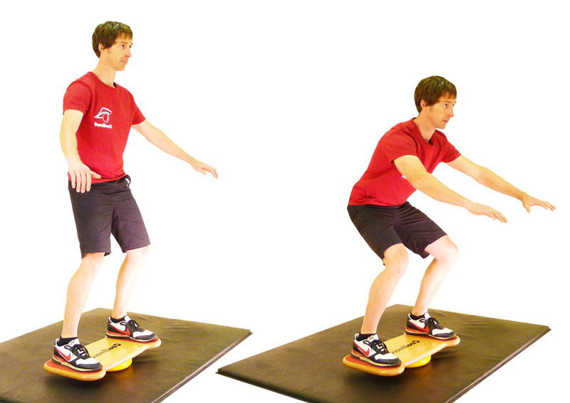 man doing squats on coolboard wobble board on disc