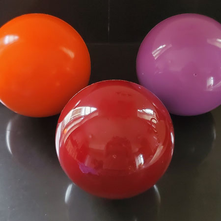 Balls for CoolBoard Balance Board. Showing three speeds of Balls, Standard Speed in Burgundy, Slow Speed in Violet, and Quickness Speed in Orange. The only Balls to balance on, solid rubbery balls.