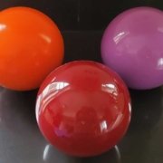 Balls for CoolBoard Balance Board. Showing three speeds of Balls, Standard Speed in Burgundy, Slow Speed in Violet, and Quickness Speed in Orange. The only Balls to balance on, solid rubbery balls.